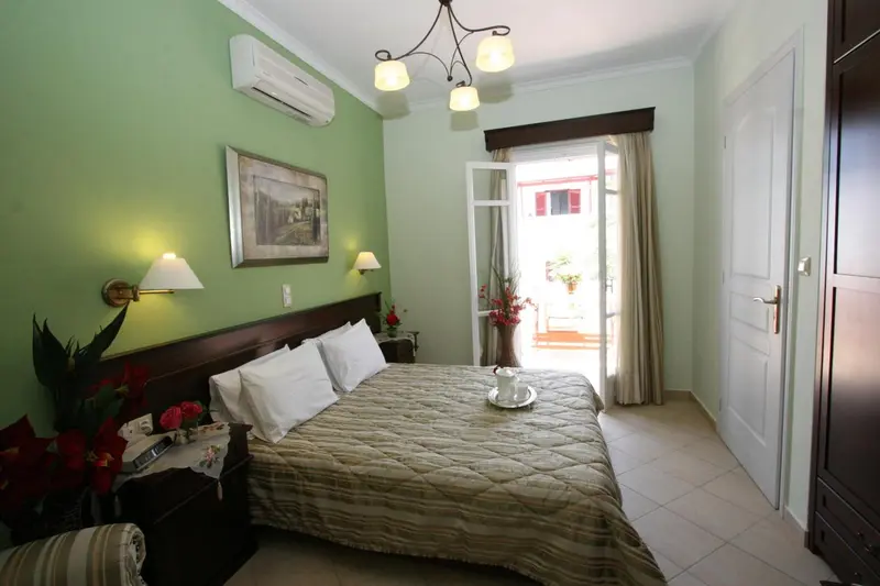 Une chambre lumineuse avec un grand lit et un accès à une terrasse.