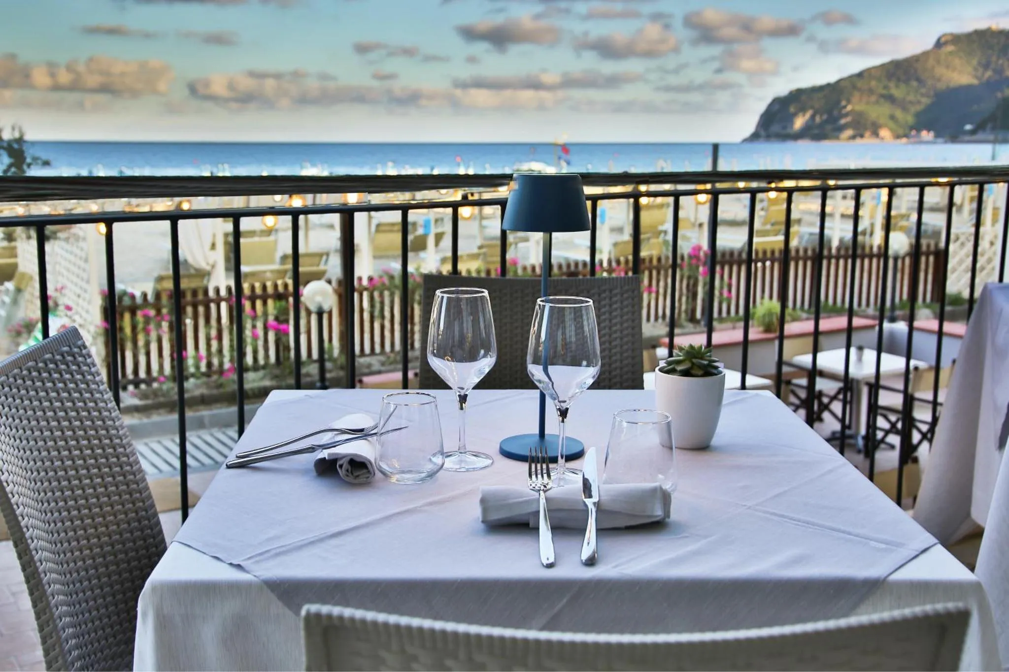 Une table est dressée sur une terrasse avec vue sur la mer.