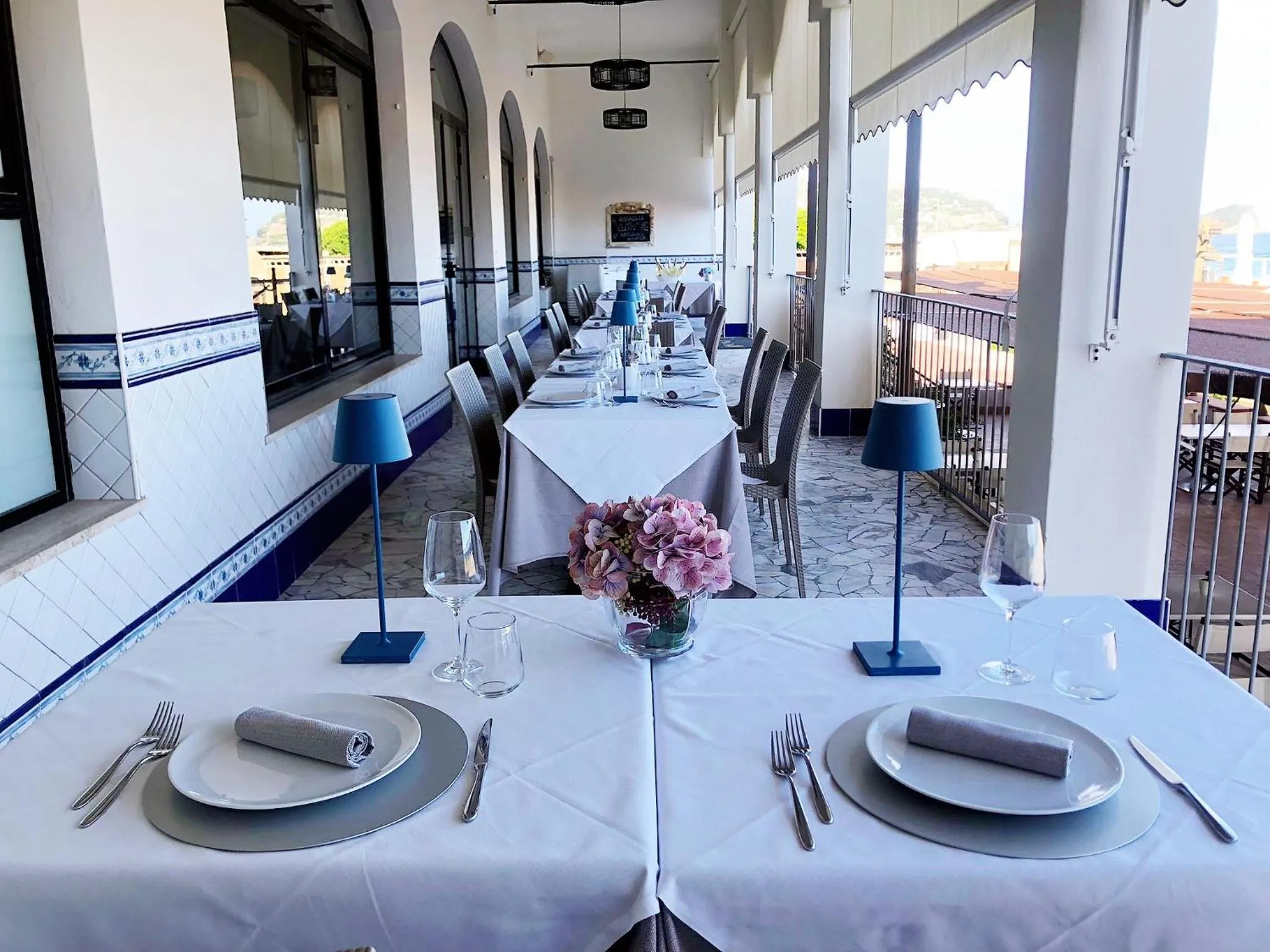 Une table dressée sur une terrasse avec vue sur la mer.
