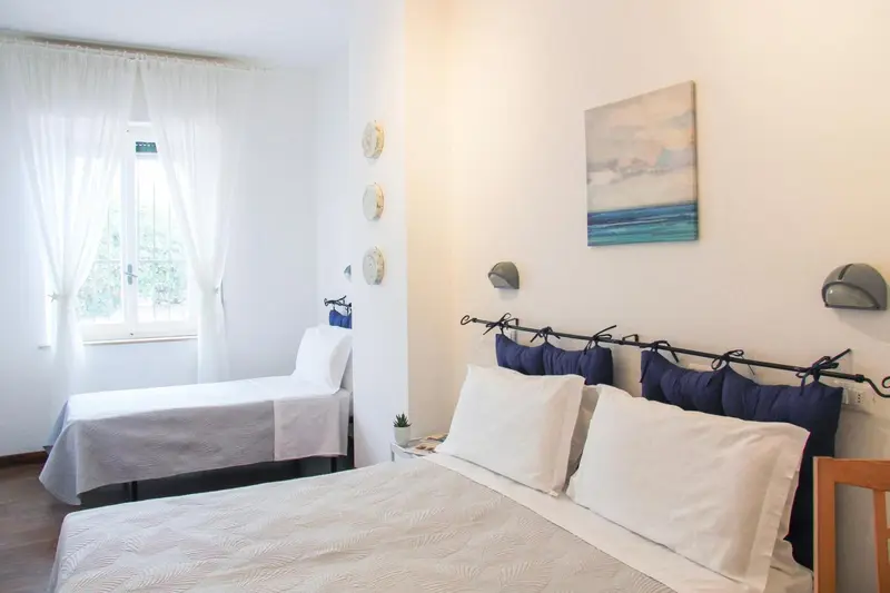 Une chambre lumineuse avec deux lits simples et une décoration murale.