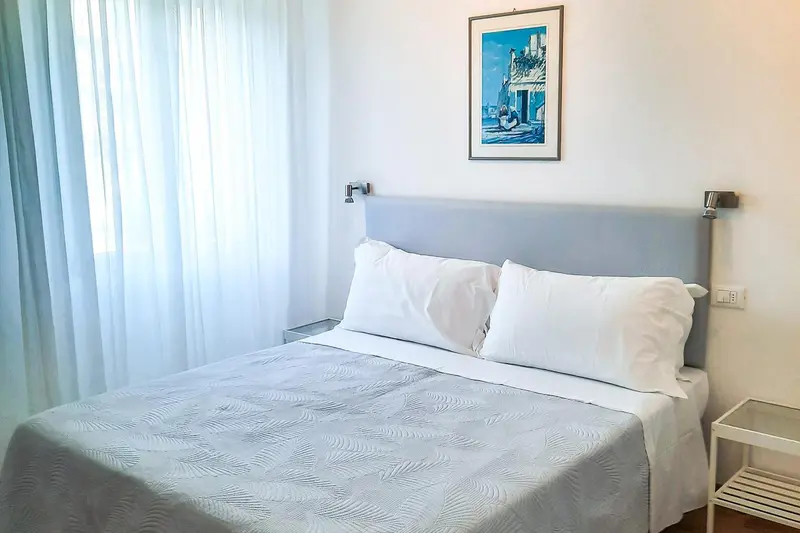 Une chambre lumineuse avec un grand lit et une décoration sobre.