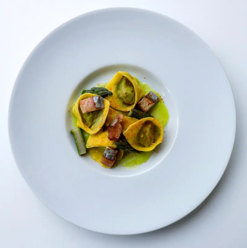 Assiette de raviolis aux asperges et à la sauce verte.