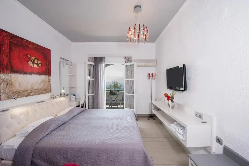 Chambre moderne avec un grand lit et un accès à un balcon.
