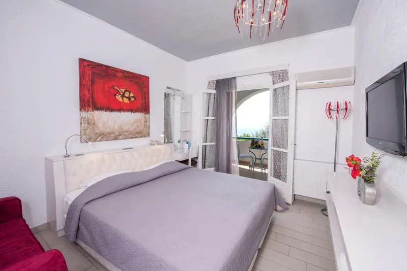 Une chambre lumineuse avec un grand lit et un accès à un balcon.