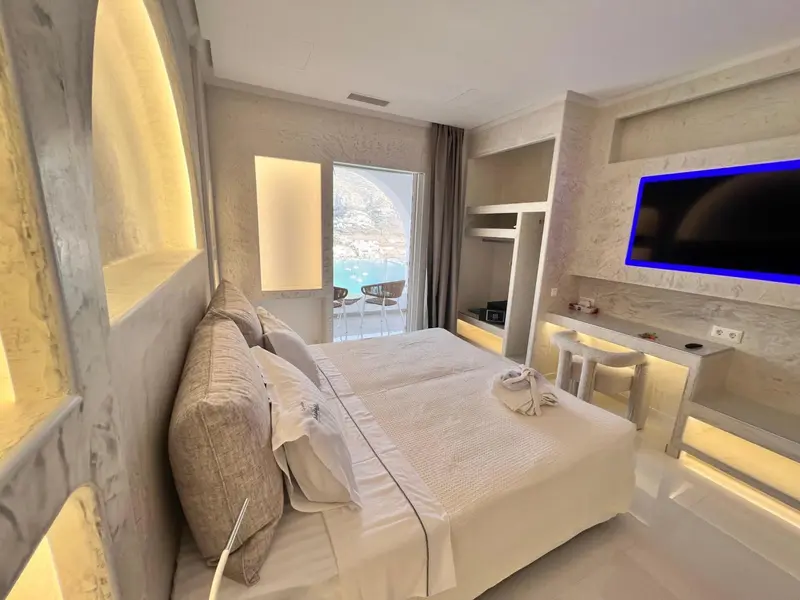 Une chambre lumineuse avec un grand lit et une vue sur la mer.