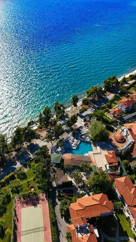 Vue aérienne d'un complexe hôtelier avec piscine et accès à la mer.