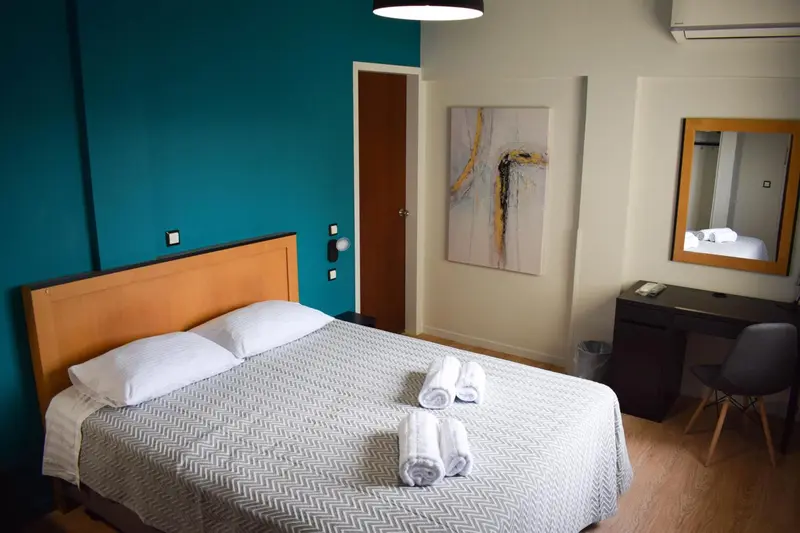 Une chambre avec un grand lit et une décoration sobre.