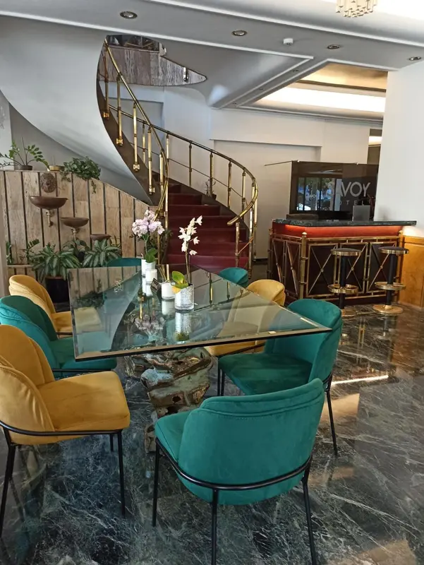 Une table et des chaises sont disposées devant un escalier dans un hall d'accueil.