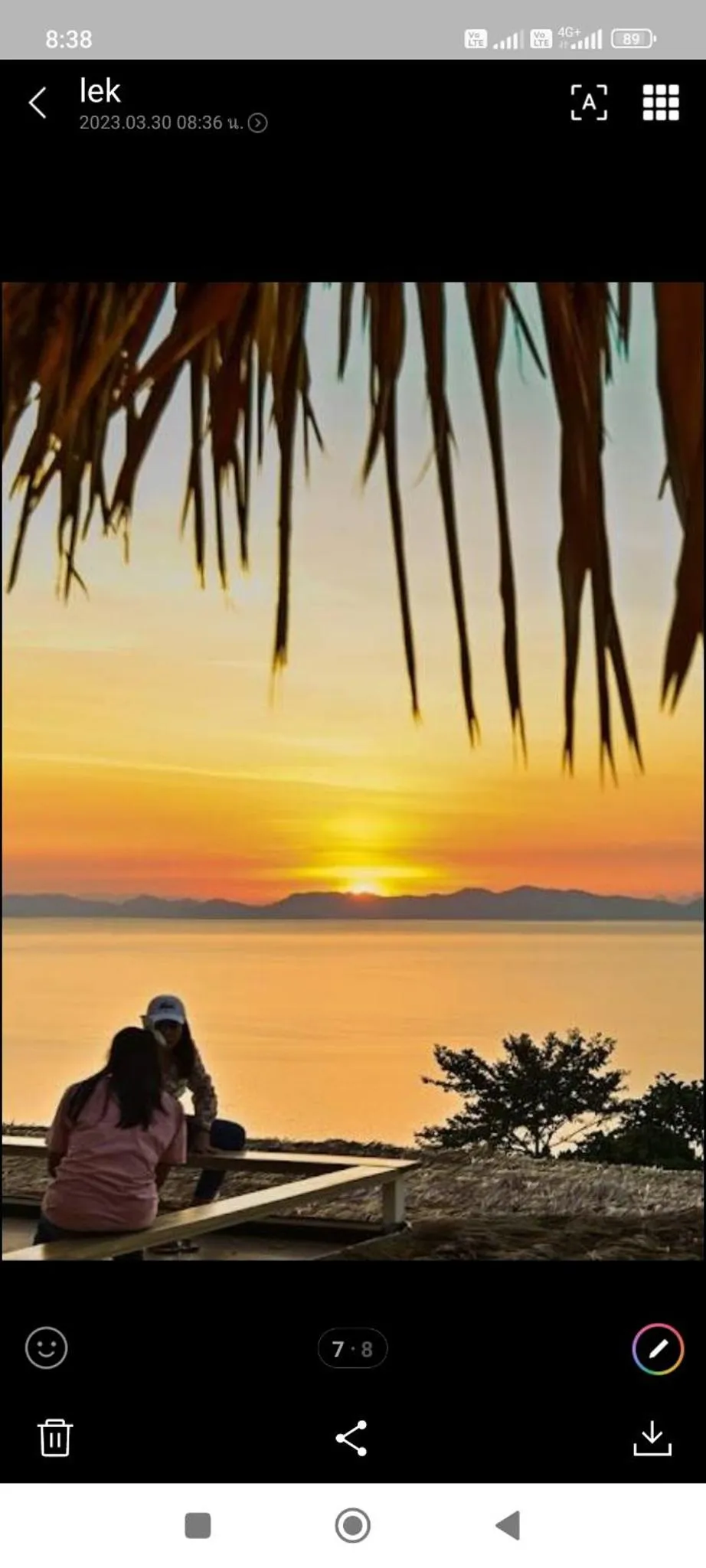 Coucher de soleil sur l'océan avec une personne assise au premier plan.