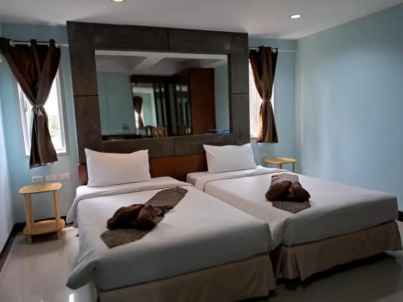 Une chambre lumineuse avec deux lits simples et une décoration sobre.