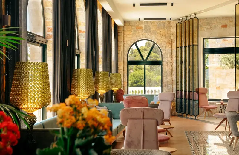 Un espace de détente intérieur avec des canapés et des fauteuils colorés, éclairé par des lampes décoratives.