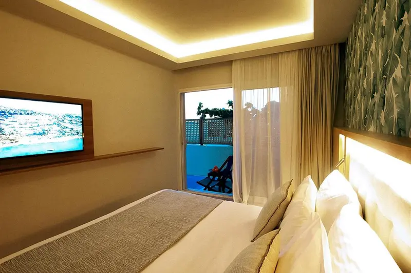 Une chambre lumineuse avec un grand lit et une vue sur une piscine.