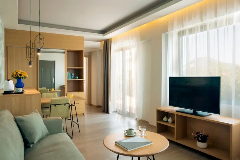 Un espace de vie lumineux avec un canapé, une table basse et une télévision.