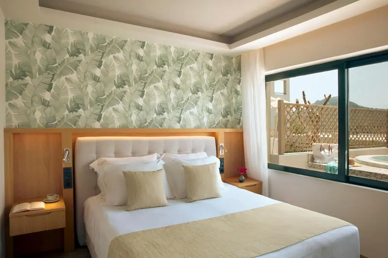 Une chambre lumineuse avec un grand lit et un décor floral.