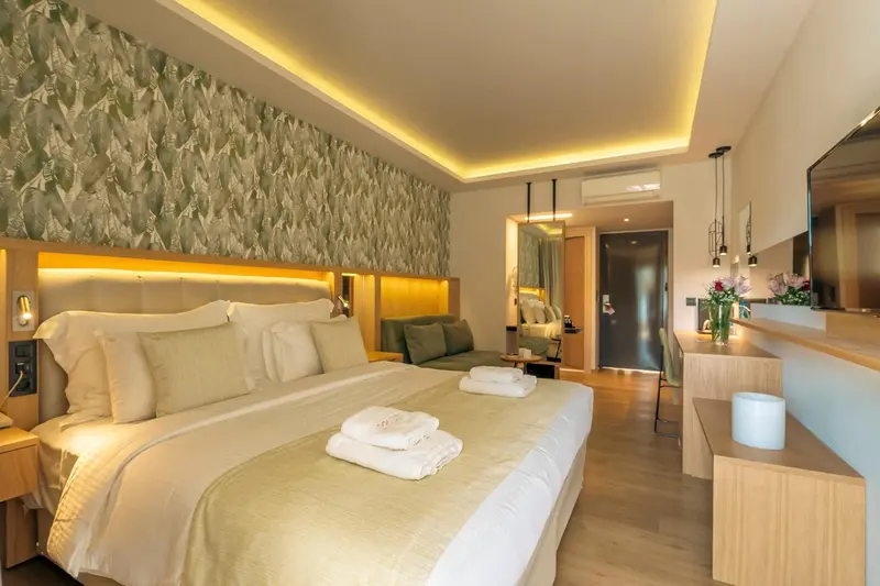 Une chambre lumineuse avec un grand lit et un coin salon.