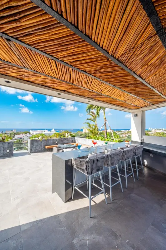 Une terrasse ombragée avec un bar et une vue sur la mer.