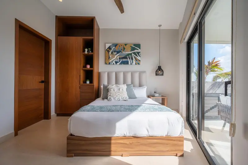 Une chambre lumineuse avec un grand lit et un accès à une terrasse.