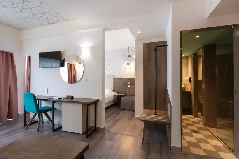 Une chambre moderne avec un bureau et un accès à une salle de bain.