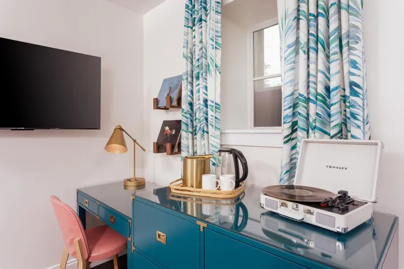 Une chambre avec un bureau, une lampe et un tourne-disque.