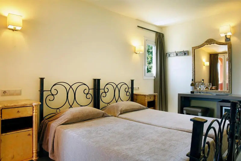 Une chambre lumineuse avec un lit à baldaquin et une coiffeuse.