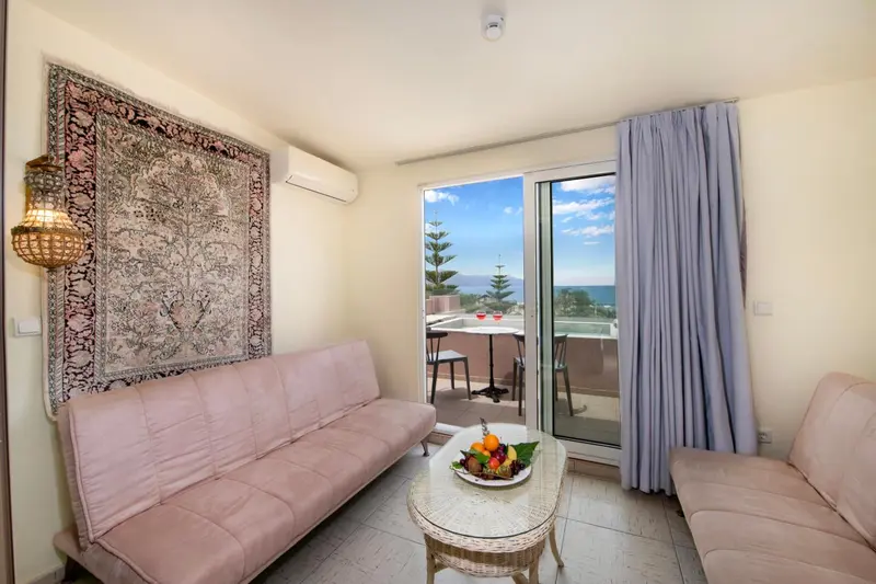 Espace de détente lumineux avec canapé et vue sur la mer.