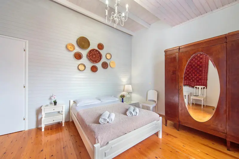 Une chambre lumineuse avec un grand lit et une décoration murale originale.