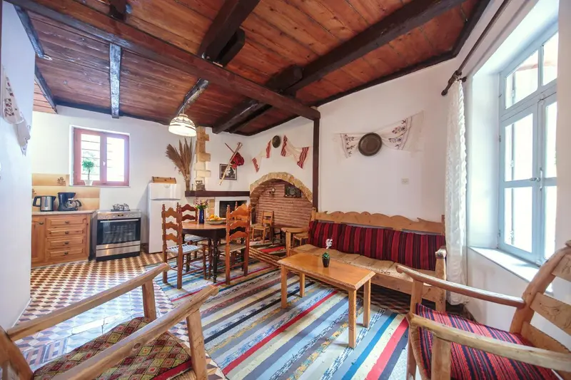 Interieur chaleureux avec coin repas, canape et cuisine.