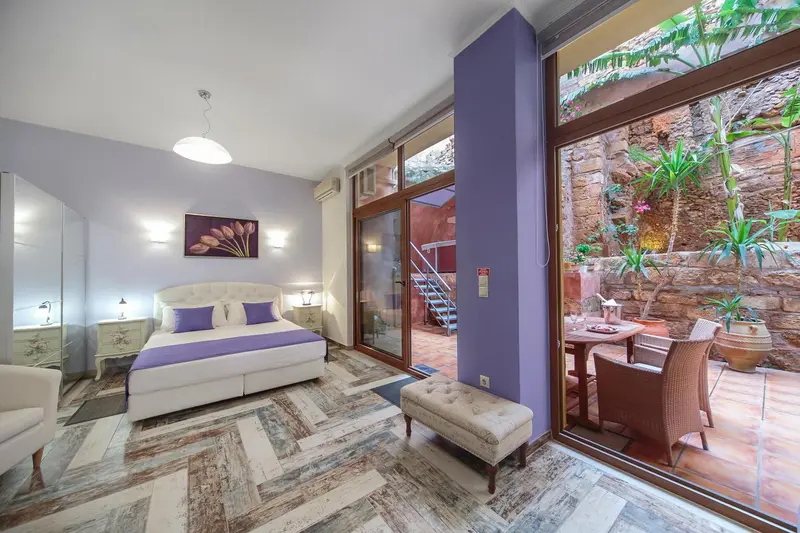 Une chambre lumineuse avec un lit double et un accès à une terrasse.