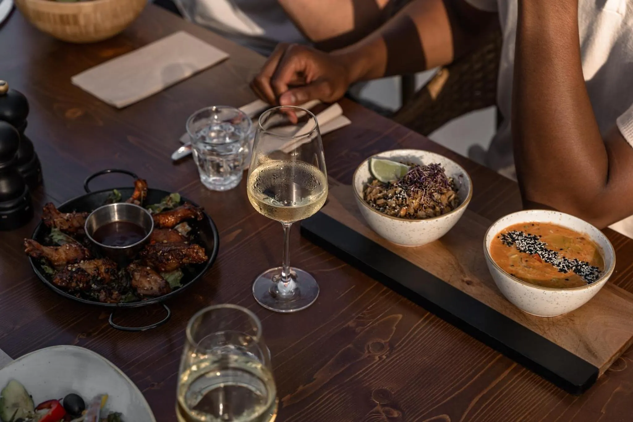 Une table en bois présente des plats variés et des boissons.