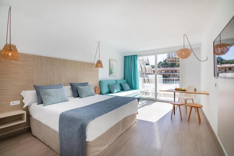 Chambre lumineuse avec un grand lit et un espace détente.