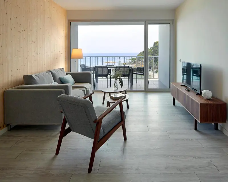 Espace de détente intérieur avec canapés et vue sur la mer.