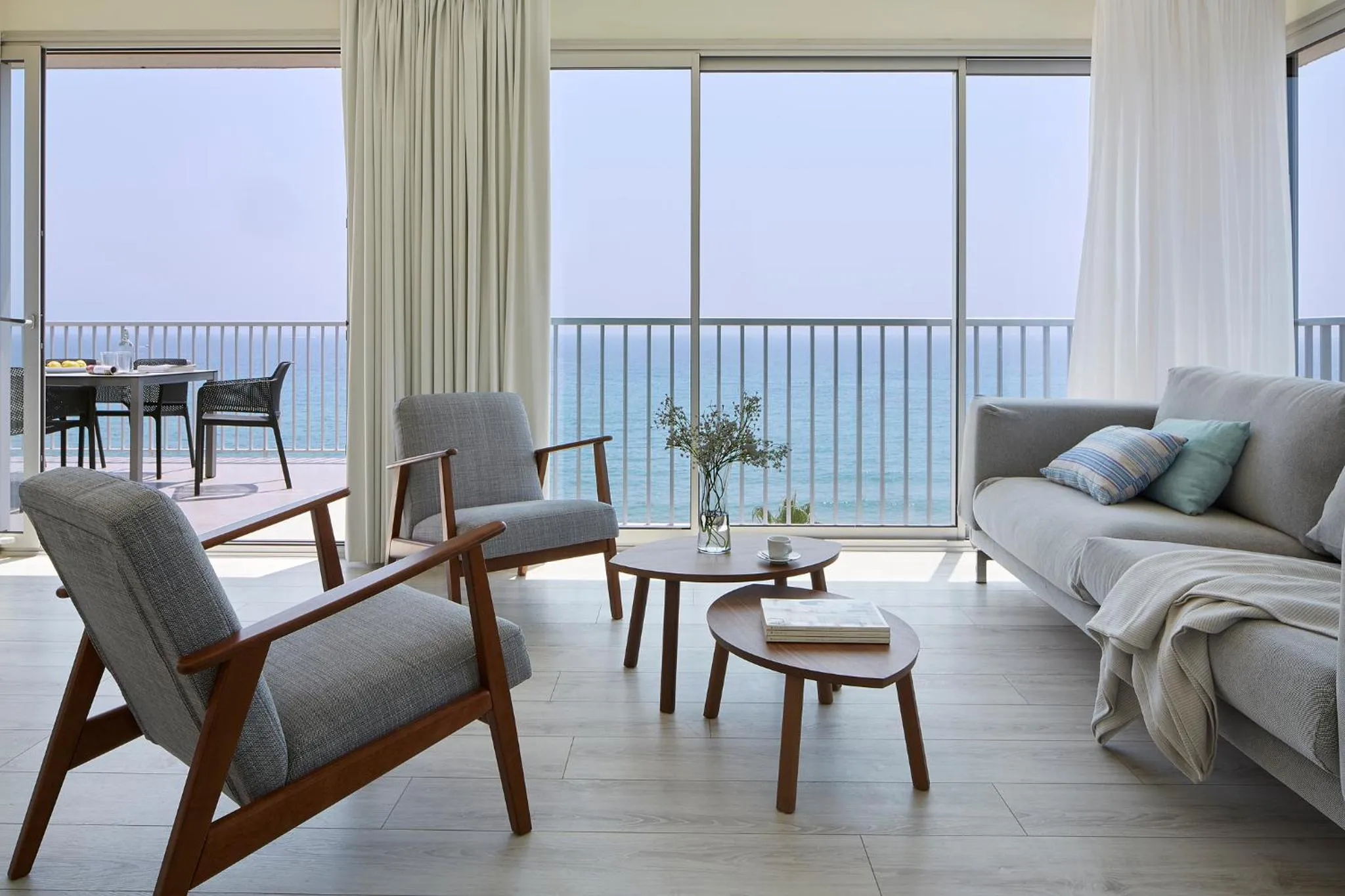 Un salon lumineux s'ouvre sur une terrasse avec vue sur la mer.