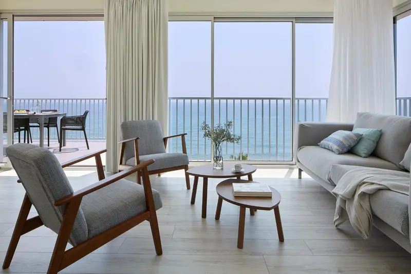 Un salon lumineux s'ouvre sur une terrasse avec vue sur la mer.