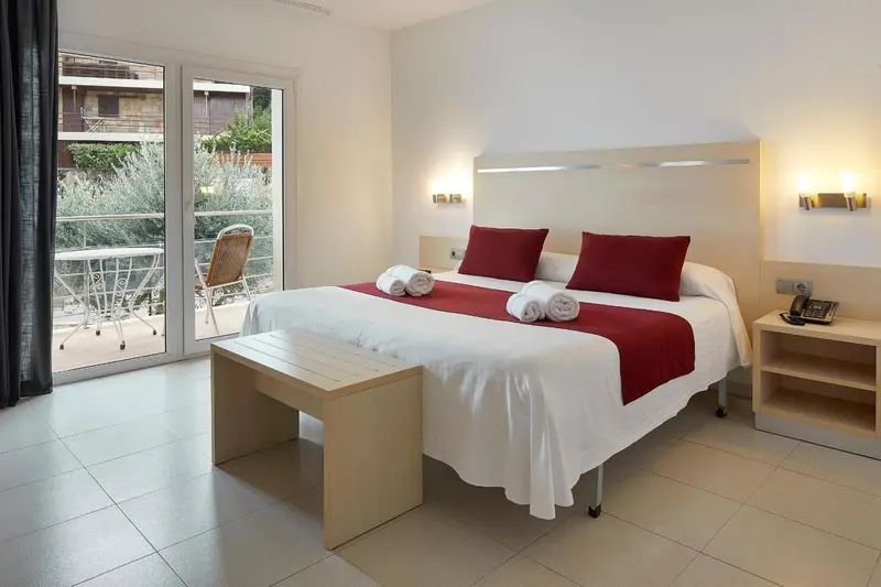 Une chambre lumineuse avec un grand lit et un accès à une terrasse.