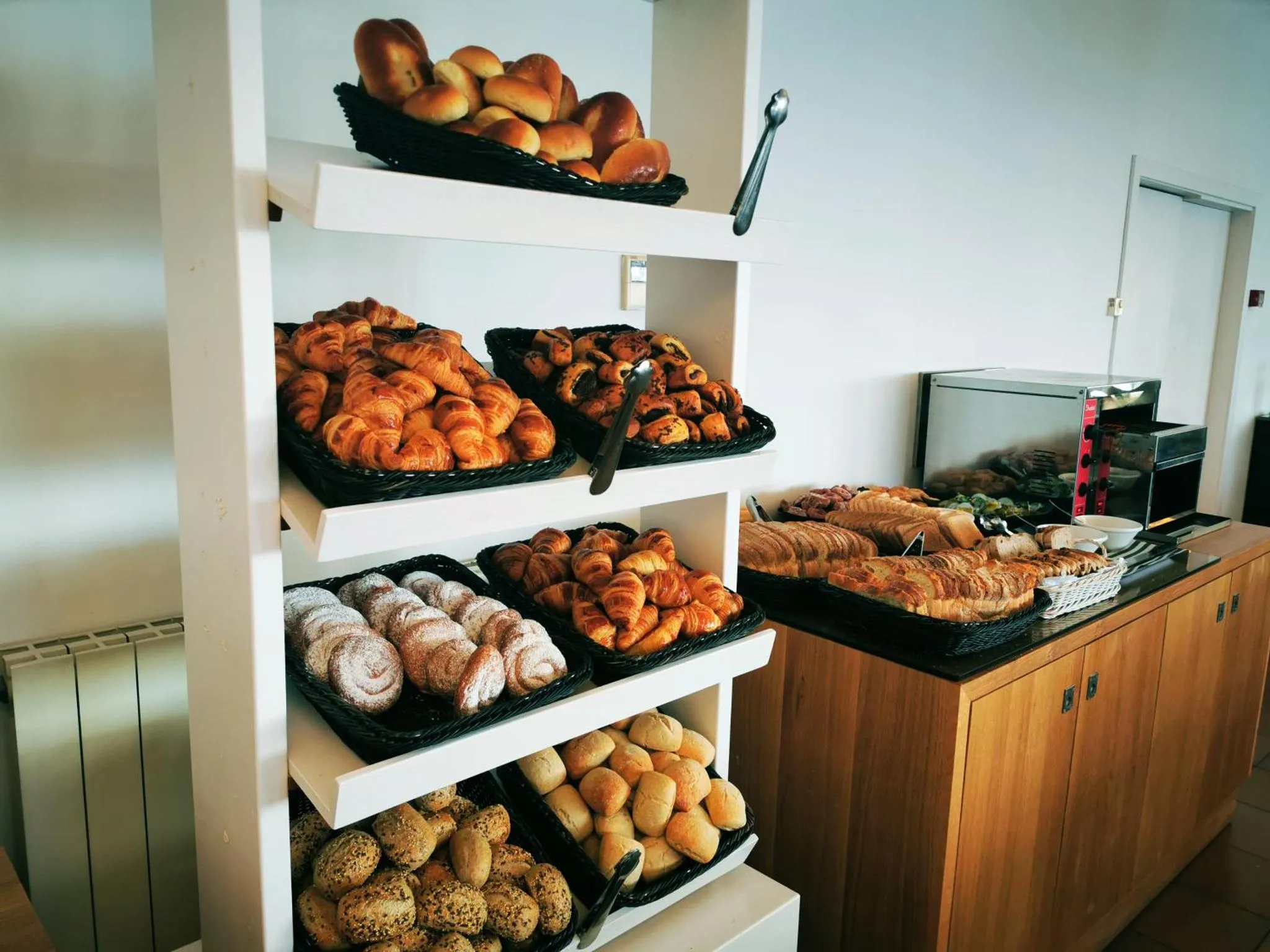 Présentation de viennoiseries sur des étagères en bois.