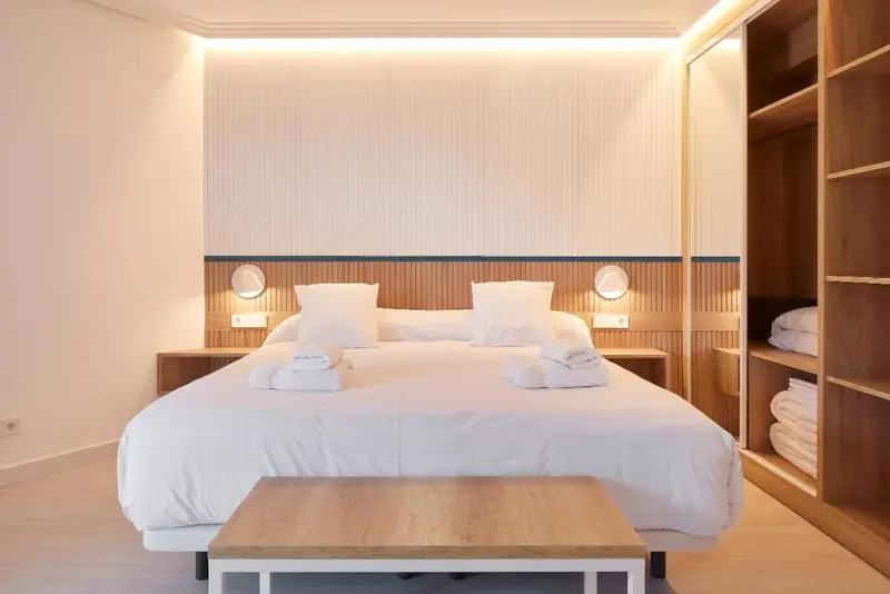 Une chambre lumineuse avec un grand lit recouvert de linge blanc.