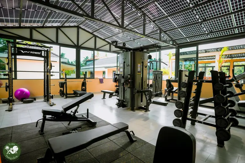 Une salle de sport lumineuse avec des équipements de musculation et des tapis de sol.