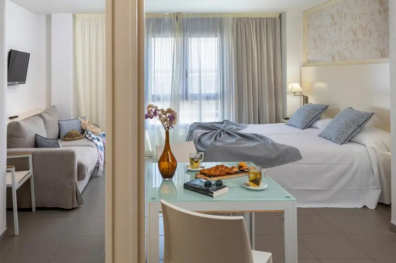 Une chambre lumineuse avec un coin repas et un canapé.
