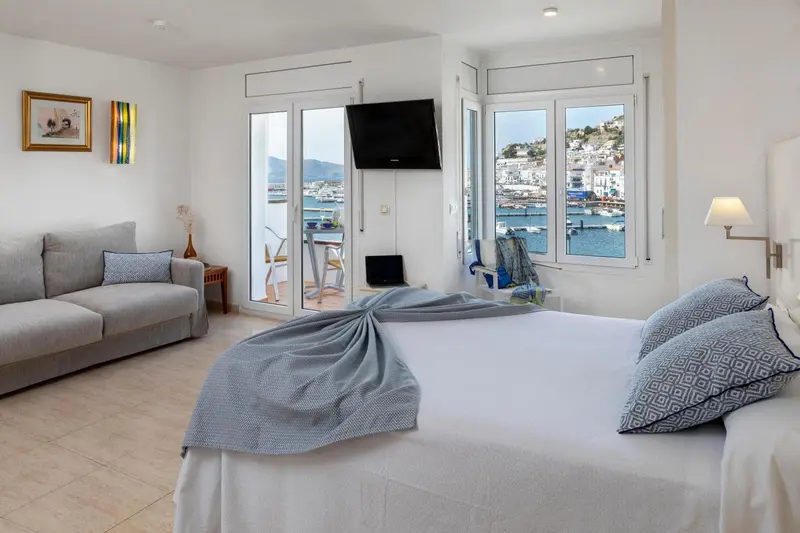 Une chambre lumineuse avec un canapé et un lit donnant sur une vue mer.