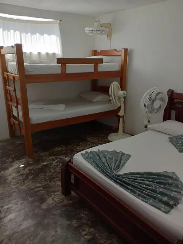 Une chambre avec des lits superposés et un lit simple.