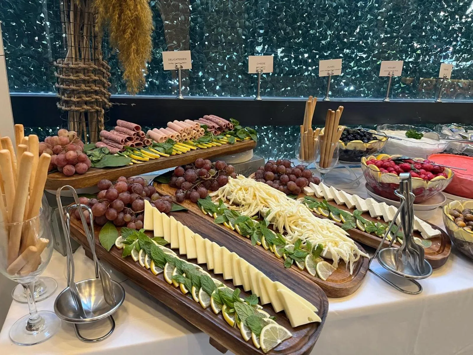 Présentation de charcuteries, fromages et fruits frais sur un buffet.