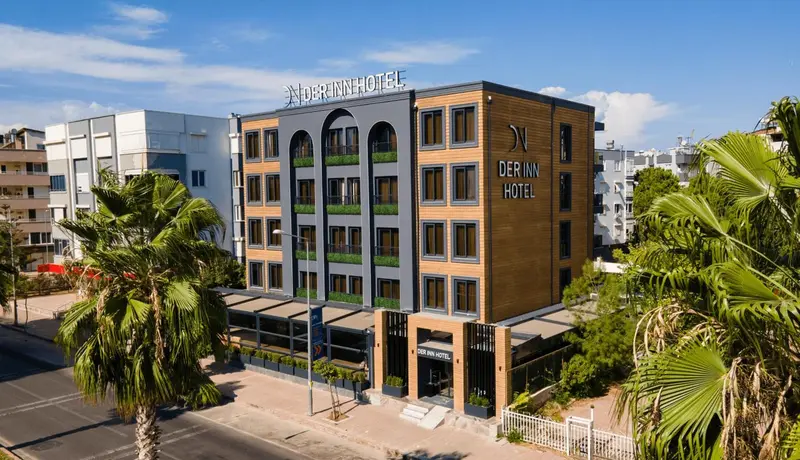 Façade d'un bâtiment moderne avec des balcons et une végétation luxuriante.