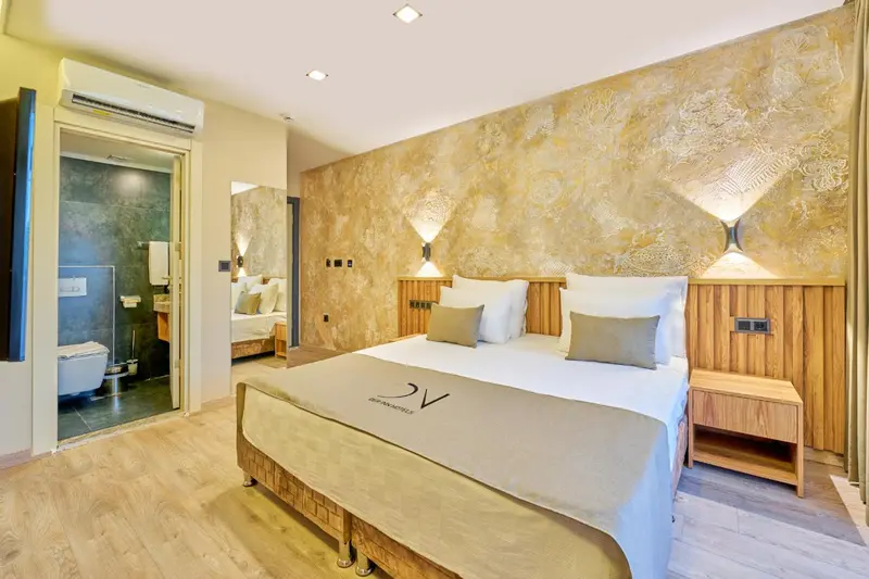 Chambre à coucher lumineuse avec un grand lit et une salle de bain attenante.