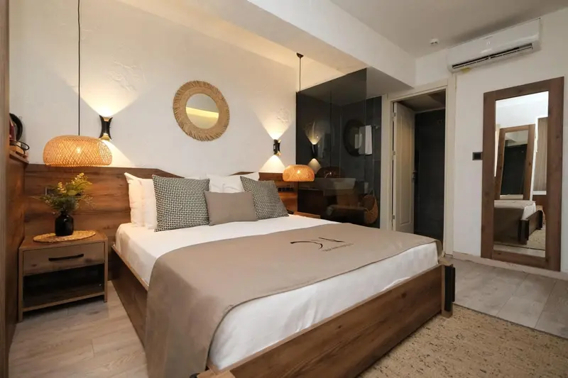 Une chambre lumineuse avec un grand lit et une décoration murale en bois.