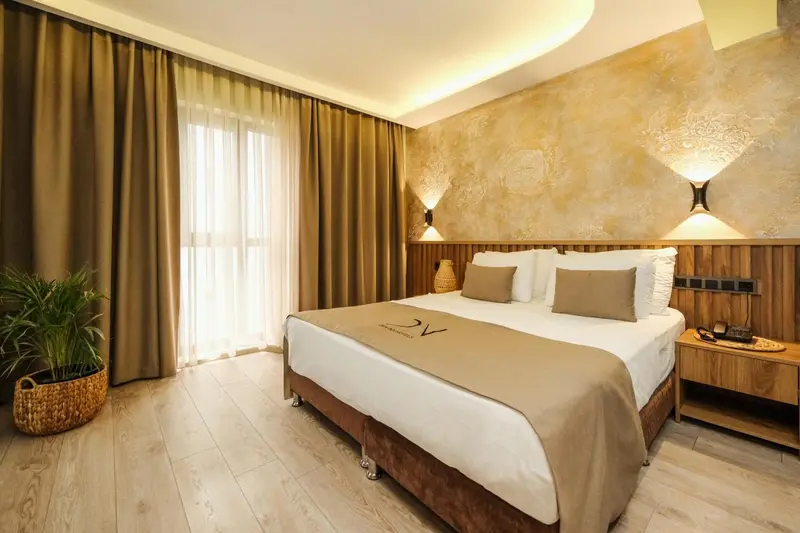Une chambre lumineuse avec un grand lit recouvert d'une courtepointe.