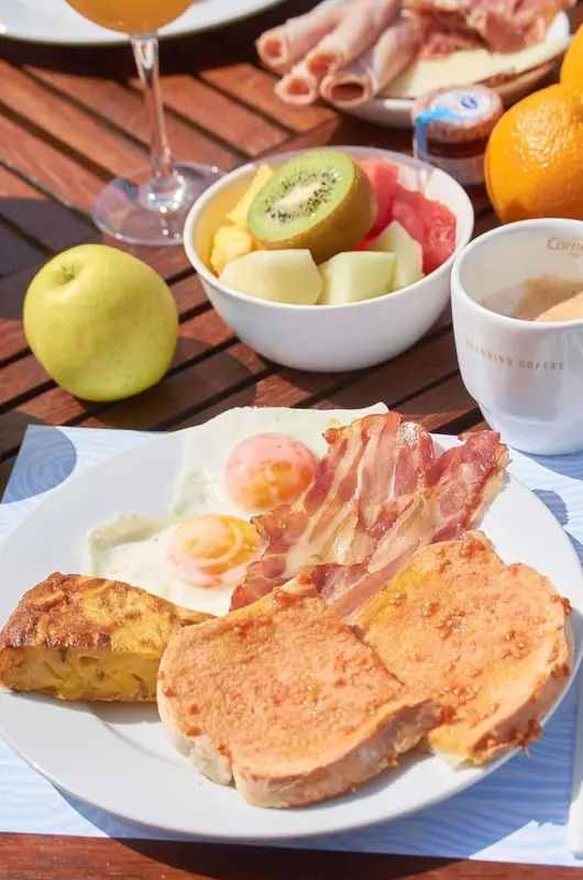 Un petit-déjeuner copieux est présenté sur une table en bois.