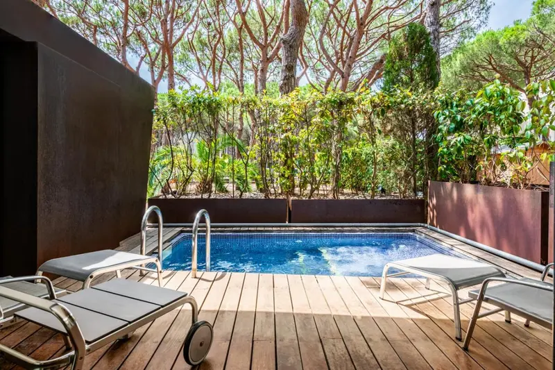 Terrasse avec piscine et chaises longues.