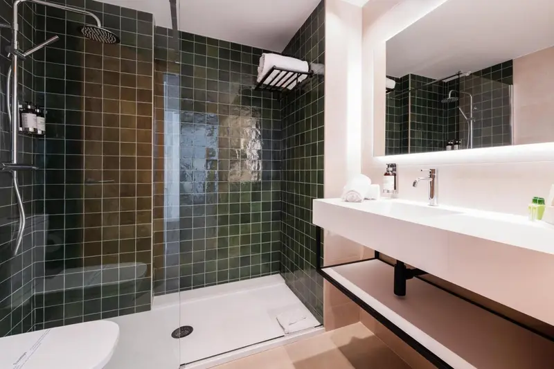 Une salle de bain moderne avec une douche à l'italienne et un lavabo blanc.