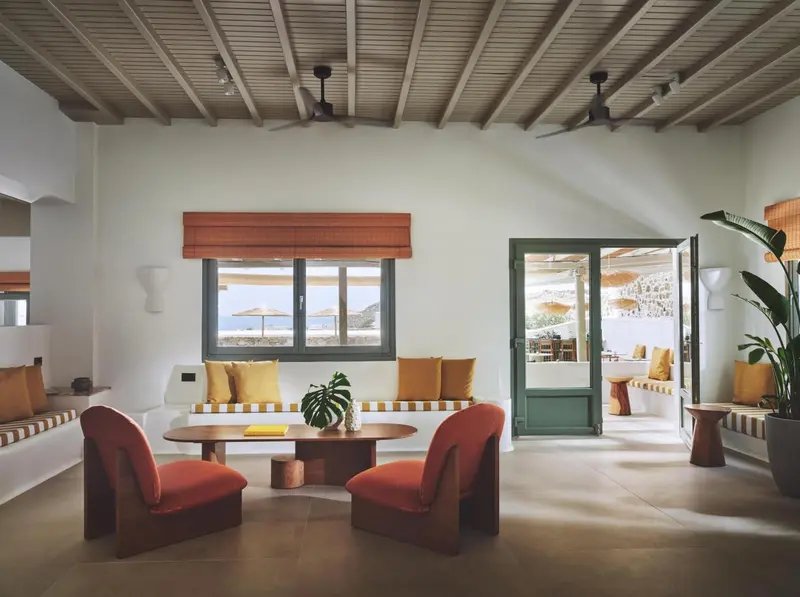 Espace de détente intérieur avec canapés et fauteuils colorés.