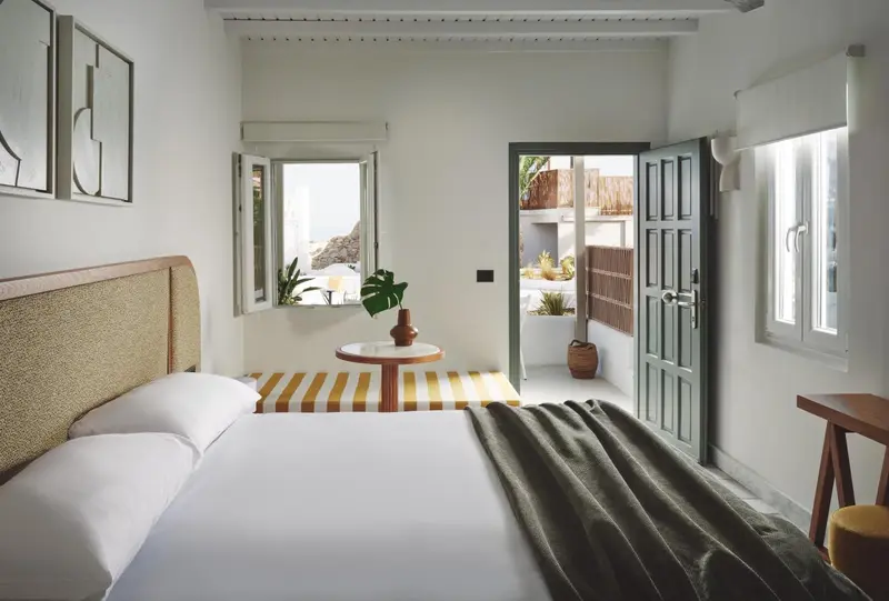Une chambre lumineuse avec un lit et un accès à une terrasse.